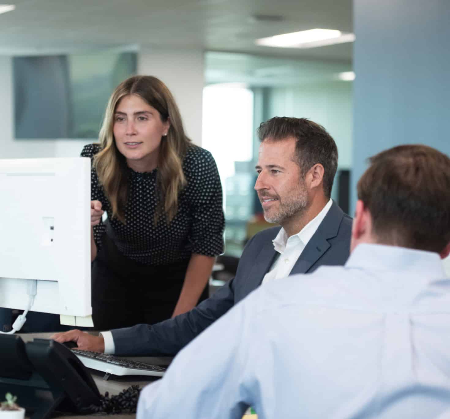 Two office workers reviewing sustainability reports at a workstation
